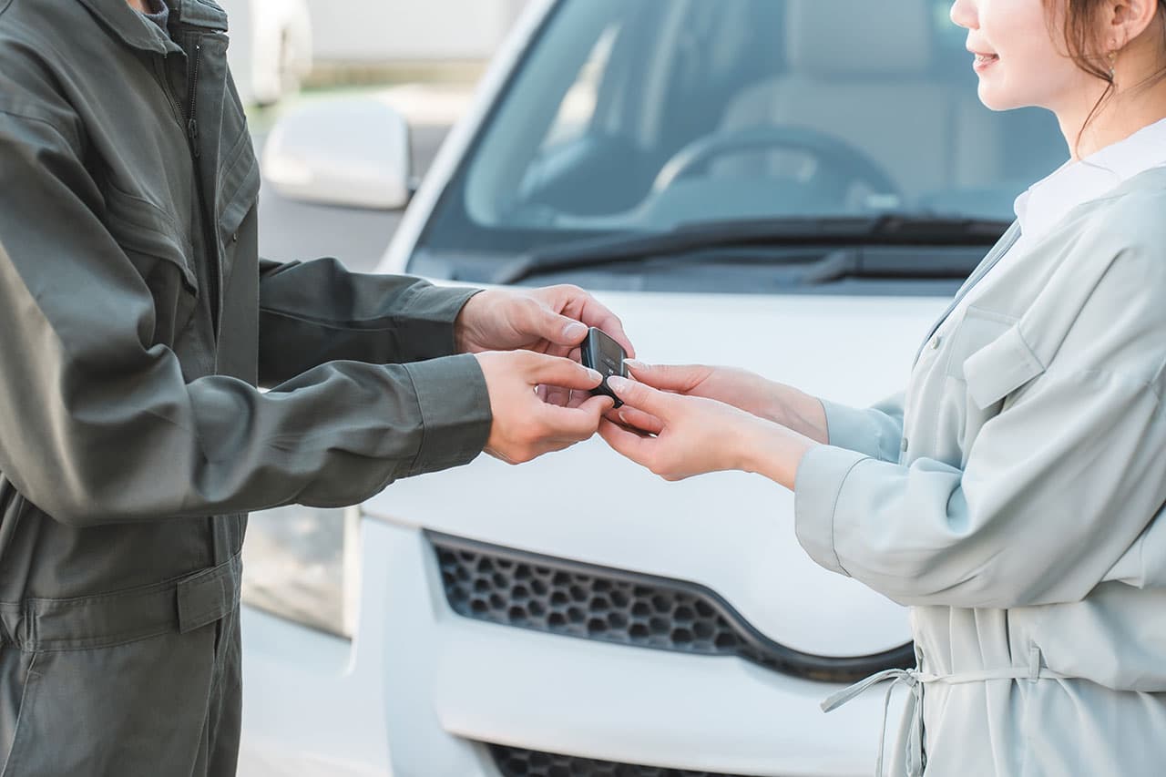 整備士からお客様へ車のカギを渡している様子